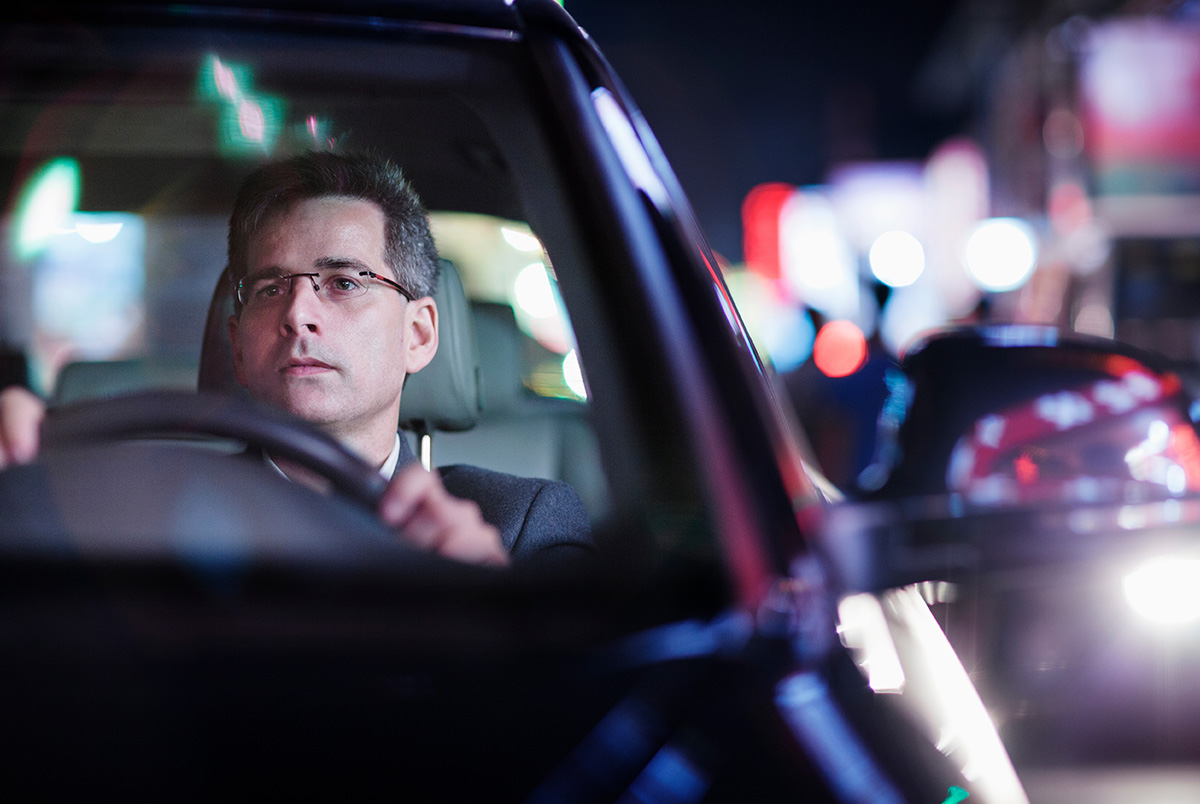 A man driving at night to highlight the importance of breaking bad driving habits on slick roads.