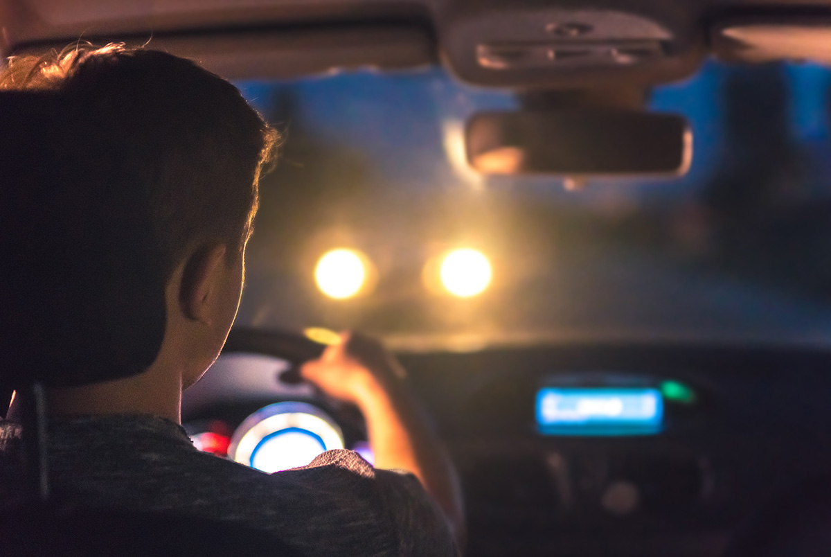 A driver looking at the front window at oncoming headlights as part of our Impaired Driving Series.