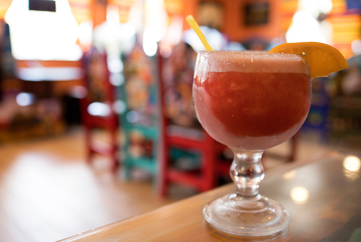 A red margarita with a restaurant blurred in the background for Cinco de Mayo. Alcohol-impaired driving accidents are preventable.