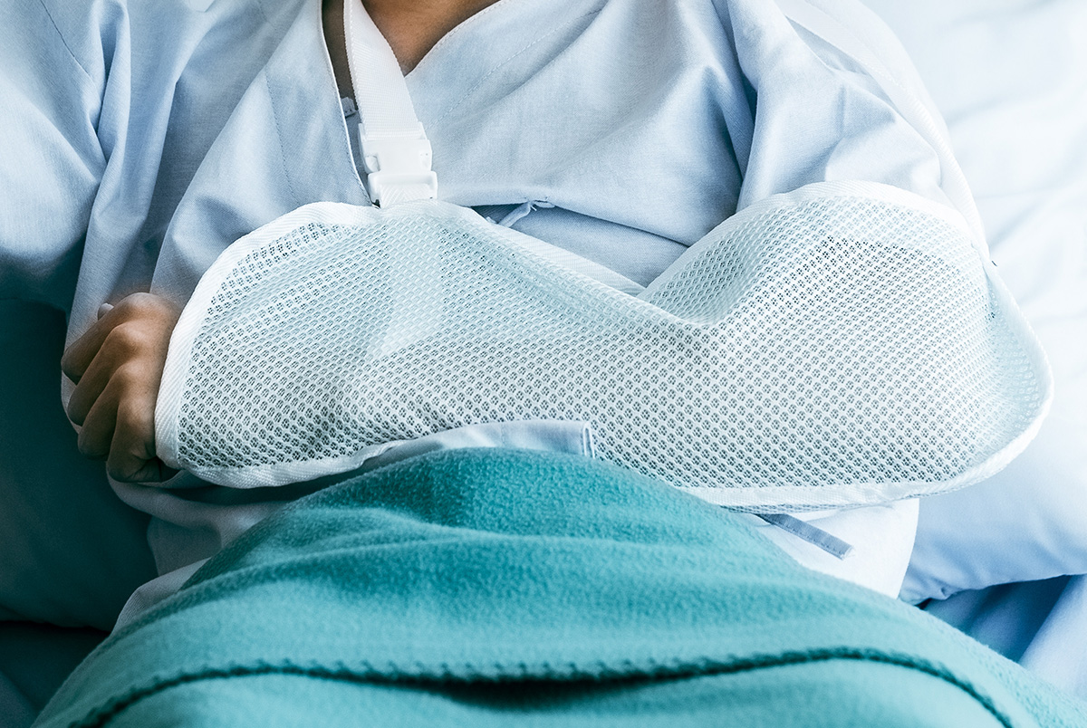 A close up of a hospital patient's arm in a sling to represent slip vs trip vs fall.