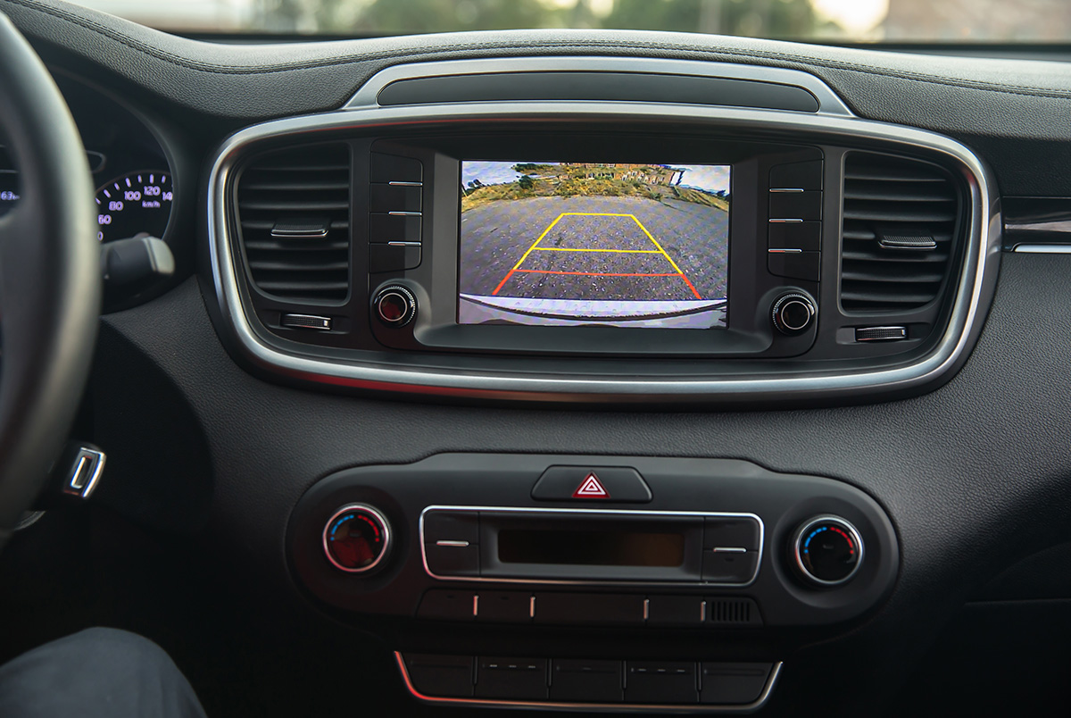 A close up of a backup camera showing empty road behind the car.